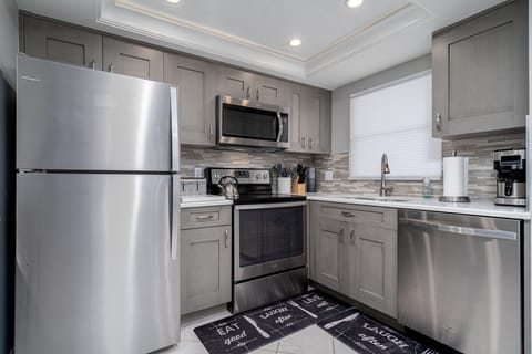 Updated with beautiful quartz countertops, tile backsplash, and shaker cabinets. The kitchen has ample room to cook!