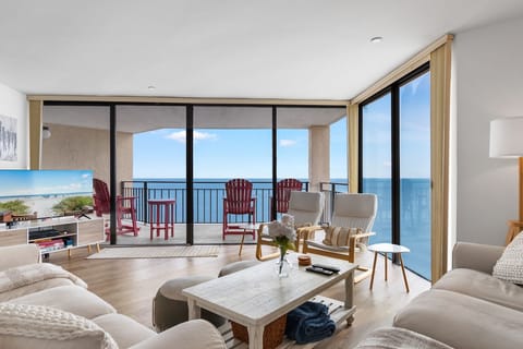 Relax in your bright living room with floor-to-ceiling windows framing endless ocean views and your private balcony.