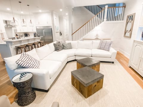 living area with large sectional and swivel chairs, open to kitchen 