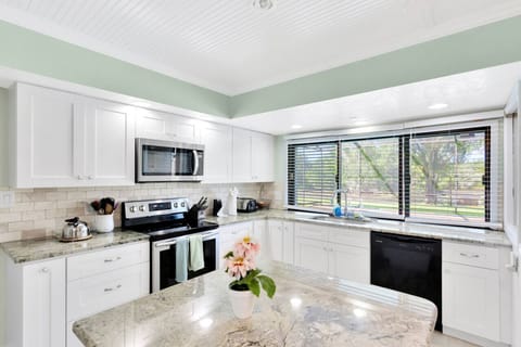 Well equipped kitchen with pool and pond views.