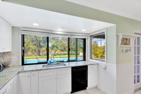 Well equipped kitchen with pool and pond views.