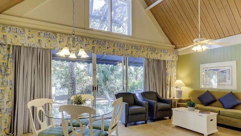 Lounge by wide glass doors as sunlight fills the room.