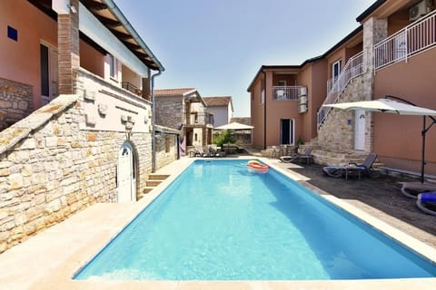 The swimming pool with deck chairs and umbrellas for shared use.