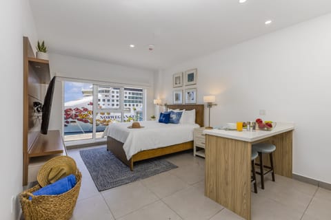 Your bright studio features a comfy queen bed with crisp linens, a convenient breakfast bar for morning coffee, and modern wood furnishings throughout. Relax and enjoy city views from your private balcony.