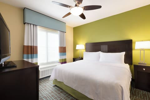 Unwind in a crisp, sunlit bedroom with cozy bedside glow.