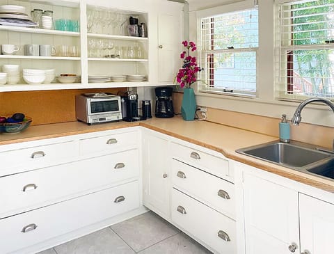 Kitchen includes drip coffee pot, dishes, silverware, pots and pans, and blender