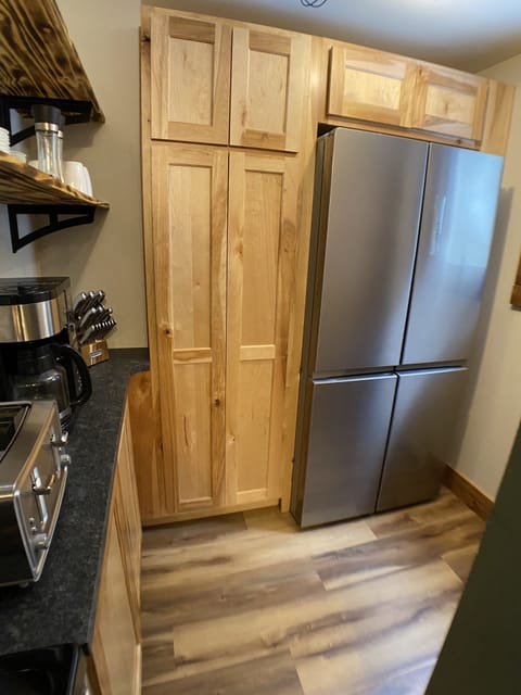 Refrigerator and large pantry cabinet for food storage.