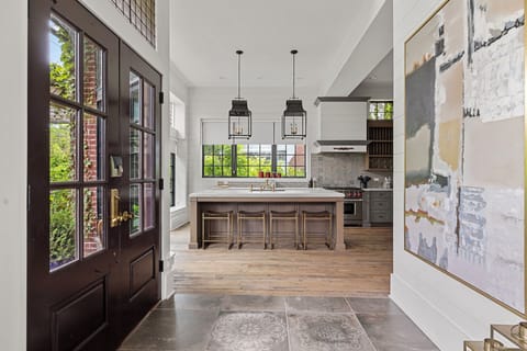Enjoy a wide array of seating options for meals including these 4 chic stools at the white marble island.