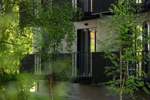 A landscaped outdoor area with trees and a water feature near a residential building.