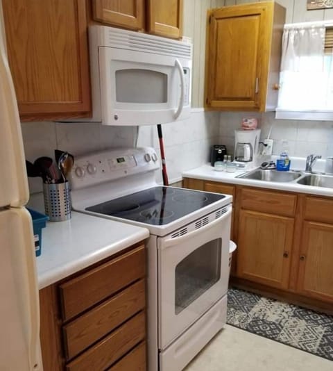kitchen area with microwave, toaster, coffee pot, refrigerator