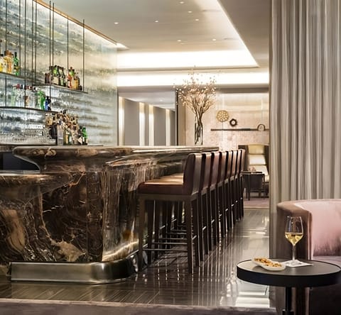 Sip cocktails at the dramatic marble bar with warm ambience.