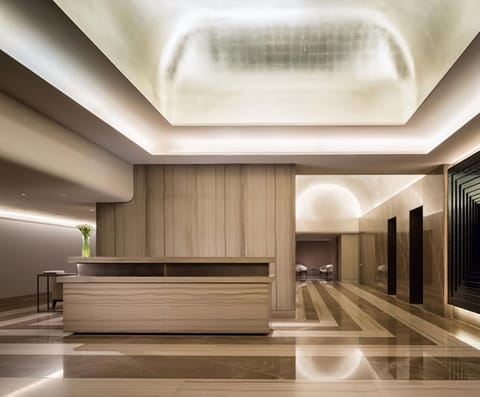 Step into a serene, designer lobby with warm lighting.