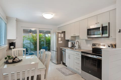 Beautiful new kitchen with stainless appliances and a sliding door that leads to the screened lanai