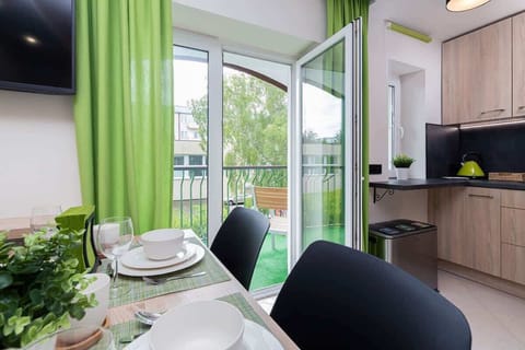 A closer look at the dining setup, highlighting tableware and decor with a view of the vibrant green curtains in the background.