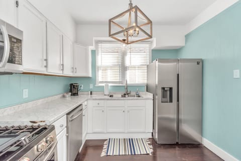 Feeling The Blues: Cooking up a storm in this sleek kitchen with its stunning blue walls and shiny stainless steel appliances. #KitchenGoals 