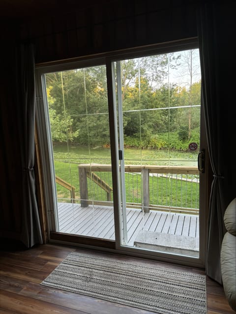 Sliding glass door out to back deck and view of woods across the channel.