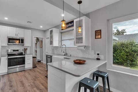 Modern kitchen with large island, seating, and stainless appliances.