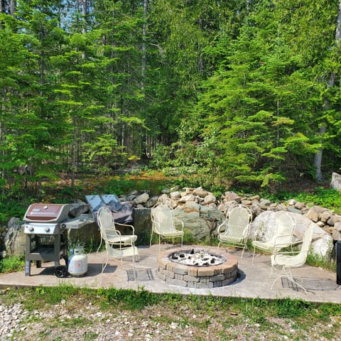 Firepit with Webber Spirit 2 grill adjacent to entryway.