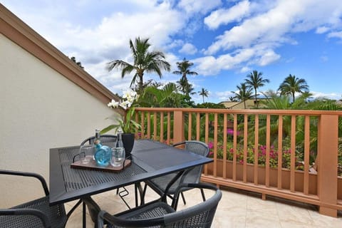 Charming outdoor dining balcony surrounded by lush tropical greenery