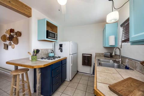 Cozy kitchen with full-size fridge and pull-down kitchen faucet.