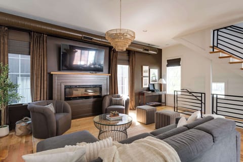 Elegant open-concept living area with upscale finishes, statement lighting, and a fireplace made for relaxing evenings