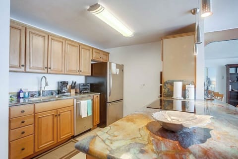 Stainless steel appliances including a dishwasher, refrigerator and freezer, microwave, and oven. Electric stovetop