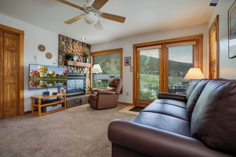 Sink into plush leather seating while enjoying your favorite shows on the large TV, with a cozy stone fireplace creating the perfect atmosphere for relaxation.