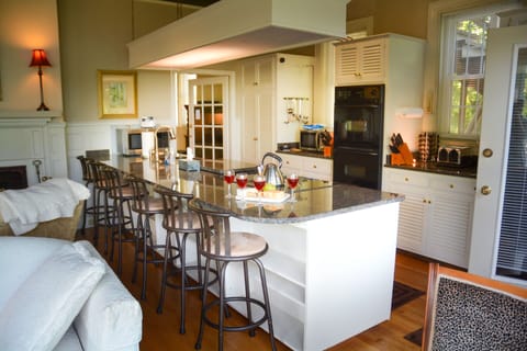 Kitchen w/ granite counters, vintage cabinets, double oven, microwave & fridge.