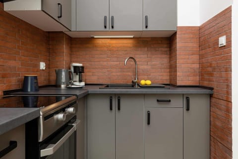 A view of kitchen essentials, including a kettle and coffee mug on the countertop, adding a homey feel.