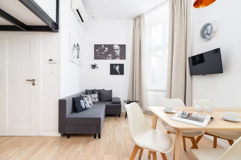 A cozy living room with a dining table and chairs, complemented by minimalist decor and neutral tones.