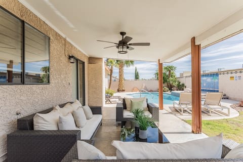 Large backyard with plenty of patio seats and a private swimming pool