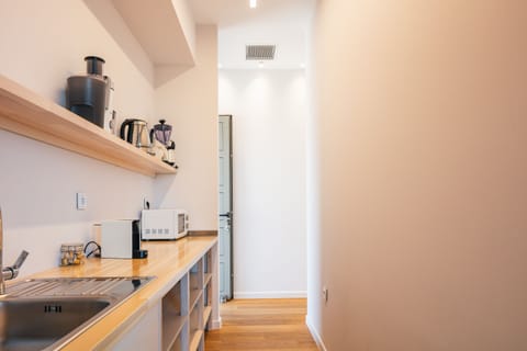 An auxiliary pantry space can be found behind the kitchen, featuring a wine cooler!