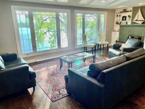 Spacious living room with wood-burning fireplace overlooks lake