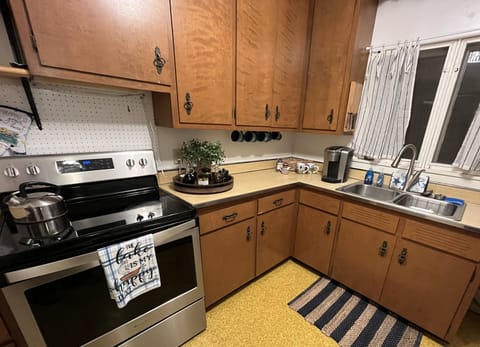 Kitchen with dishwasher, full dishes and utensils.