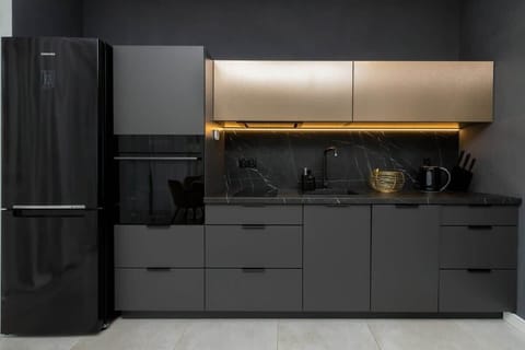 Stylish kitchen with black cabinets and yellow chairs by the table.