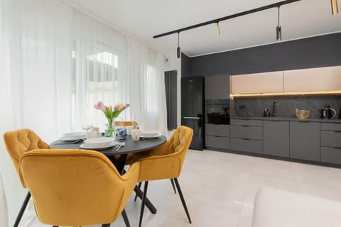 Stylish kitchen with black cabinets and yellow chairs by the table.
