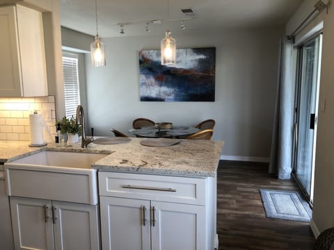 View from kitchen with farm sink, breakfast bar seats 2 and dining table for 4
