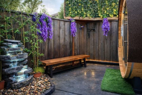 Zen backyard corner featuring a calming rock waterfall and sauna access