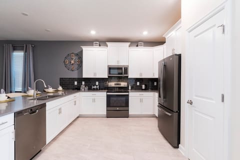 Cook up a storm in this fully equipped, modern kitchen with sleek countertops, stainless steel appliances, and a large island with a breakfast bar. Perfect for preparing family meals or quick snacks before heading out for the day!