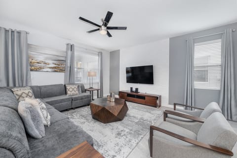 Spacious open-concept living area with modern decor, sleek kitchen, and dining.