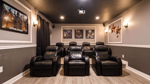 Dedicated movie theater equipped with plush seating, a large screen