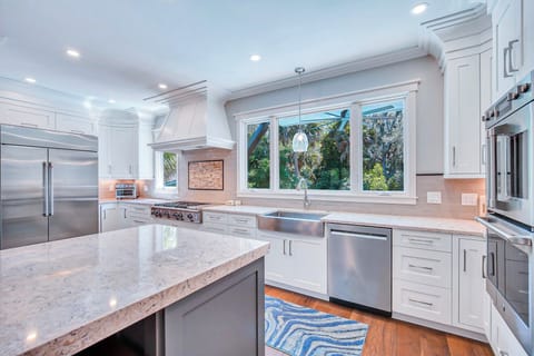 Fully stocked kitchen with stainless steel appliances.