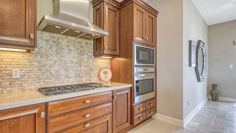 Unleash your inner chef with a natural gas range, built-in oven, and microwave—all set in a sleek, coastal kitchen made for effortless entertaining.