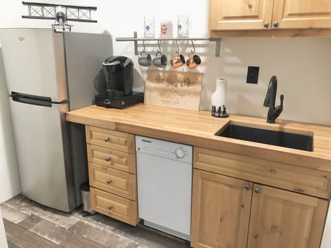 Secondary kitchen in the studio with sink, dishwasher, fridge/freezer, & Keurig