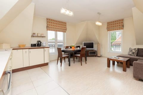 A harmonious combination of seating area and kitchenette. The whole is complemented by a wooden dining table with chairs.