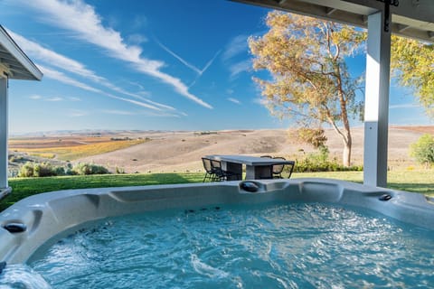 Soak beneath the covered patio with open hill views