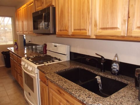 Kitchen with Granite counters and gas stove. Plenty of cabinets & cookware.