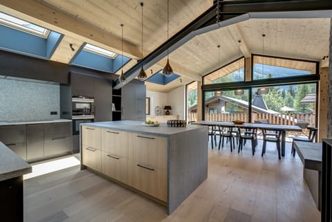 Kitchen with stone work surfaces and island with stools