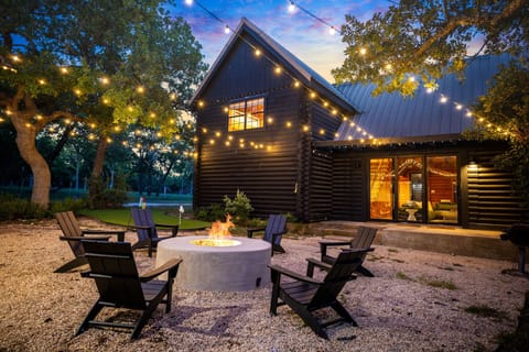 Spacious log cabin on wooded land in Fredericksburg with fire pit and lights.