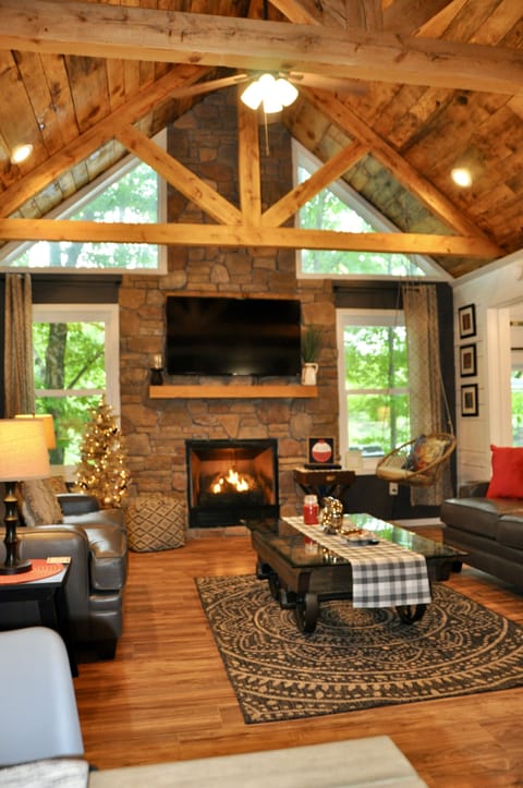 Living room overlooks Autumn Lake, custom stone gas fireplace, exposed trusses